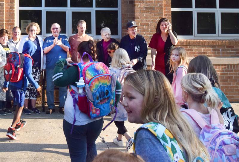Students rush to take a picture next to the bench dedicated to Eloise Anthony on Sept. 13 at Emerson Hough Elementary School. Anthony was a longtime teacher at Emerson Hough who died in 2018.