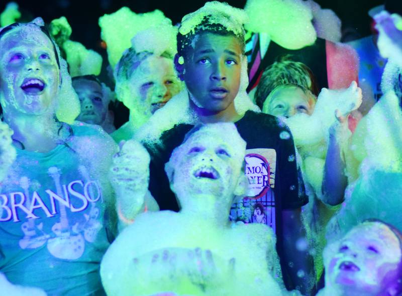Kids participate in Driving Cap Entertainment's UV Glow Foam Party during Newton Fest on June 9 in Maytag Park in Newton.