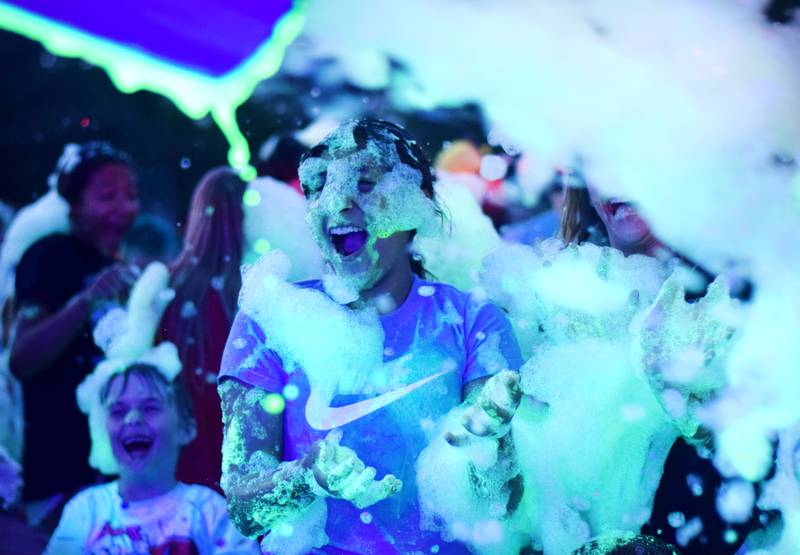 Kids participate in Driving Cap Entertainment's UV Glow Foam Party during Newton Fest on June 9 in Maytag Park in Newton.