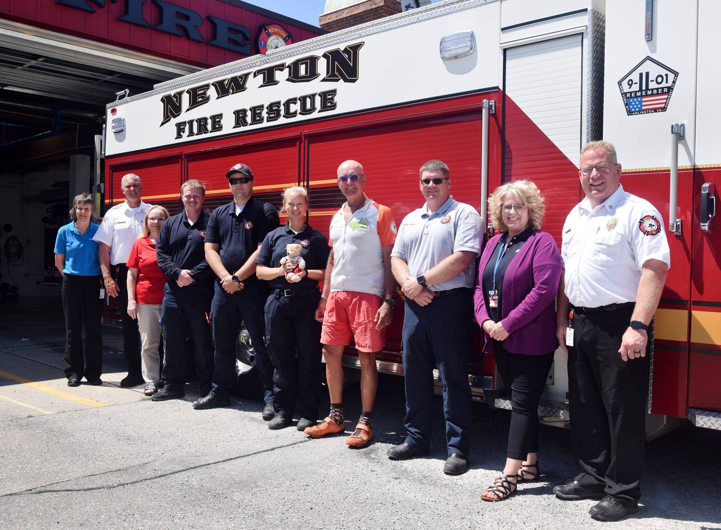 Jörg Richter, a German cyclist and former firefighter, poses for pictures with administrators, firefighters, paramedics and office staff from the Newton Fire Department. Richter made an overnight stay at the Newton fire station. He is riding across the country to bring awareness to children with rare diseases.