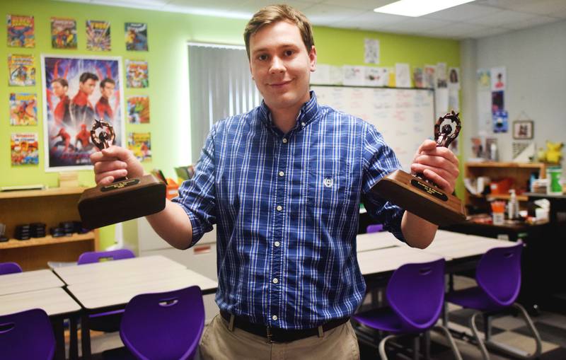 Zac Plank, a math teacher at WEST Academy, holds his two Excellence in Education Awards from Newton Community Educational Foundation. The 24-year-old teacher has earned two consecutive awards for helping students learn one of the most universally hated subjects in school.
