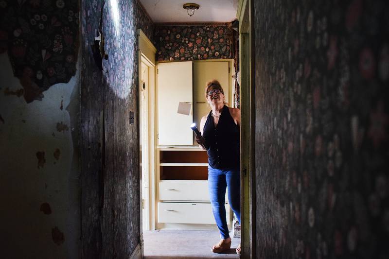 Nancy Sorbella of Carmel, N.Y., looks through the upstairs hallway of the 112-year-old property at 427 N. Third Ave. E. in Newton. Sorbella says she has become obsessed with the home, which belonged to her family at one point, and she wants to restore it back to life.