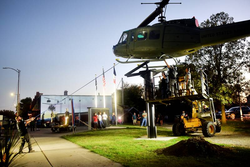 Crews pull on the Huey helicopter to get it into position on its raised platform on Sept. 30 in Baxter.