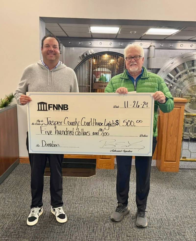 Rob Kahn from FNNB bank, presents a check for $500 from the FNNB foundation to Steve Knight, with the Courthouse lighting fund.