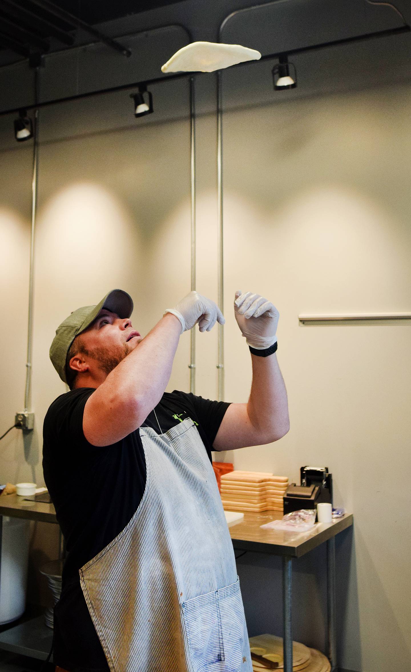 Conor Fudge, owner of Murph & Mary's Pub, tosses dough in the air inside the pizzeria kitchen of the Newton bar.