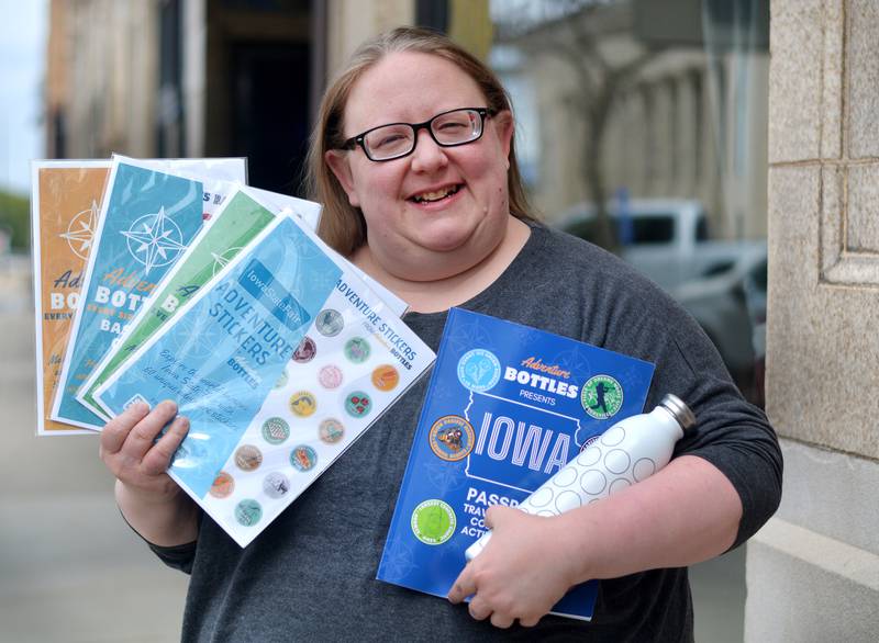 Jessica Lowe Vokes, of Newton, showcases the Adventure Bottles, the Iowa Passport Travel Journal Coloring & Activity Book and the series of stickers she has designed that feature Iowa landmarks and attractions.