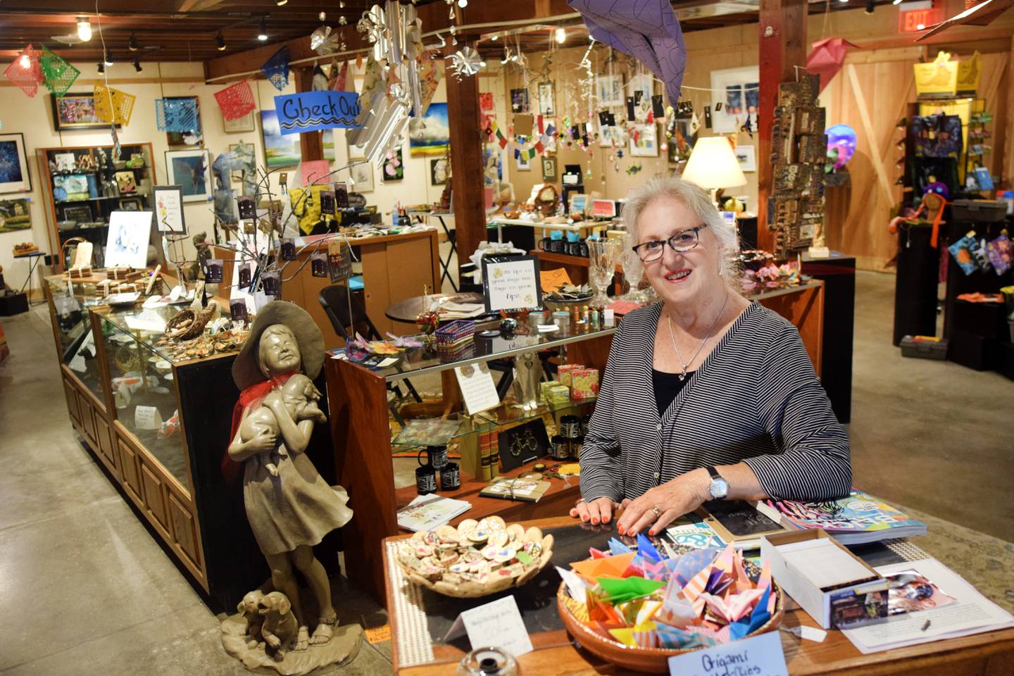 Terri Ayres, volunteer manager of the Geisler-Penquite Gift Shop at the Center for Arts & Artists, showcases the many handmade and donated items for sale at the store, the proceeds of which benefit creative-based programming and projects for youth.