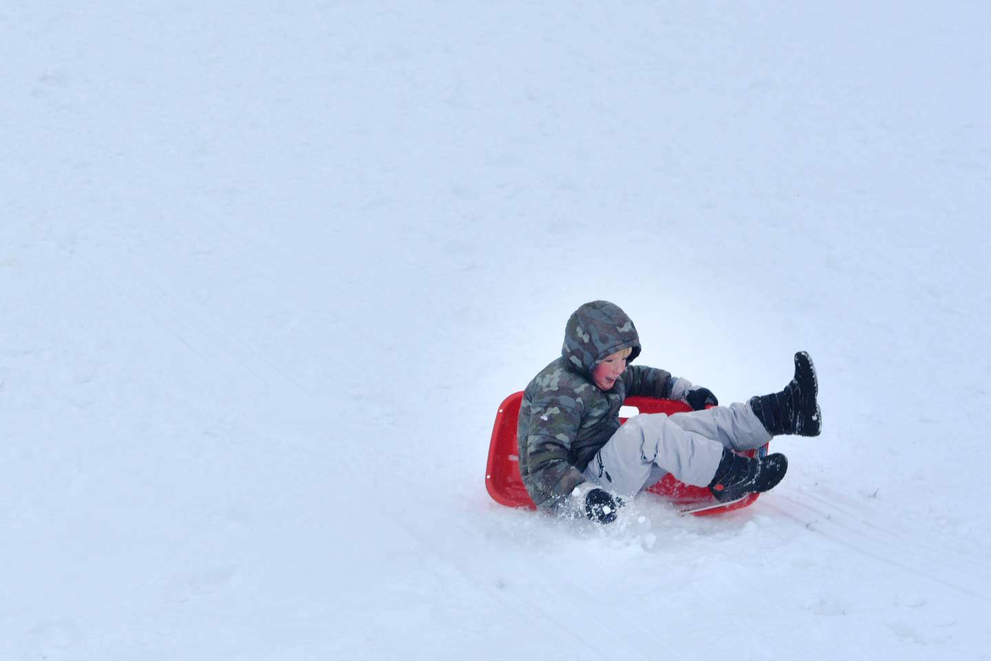 Kids in the community sled down the steep hills of Sunset Park on Sunday, Nov. 30 after the day-long snowstorm the day before.