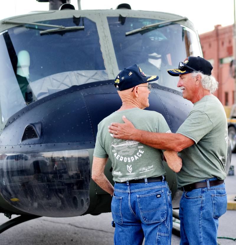 Lynn Harnden and Greg Christianson share a handshake while taking one final look at the Huey helicopter up close before it is posted as a memorial for Vietnam War veterans.