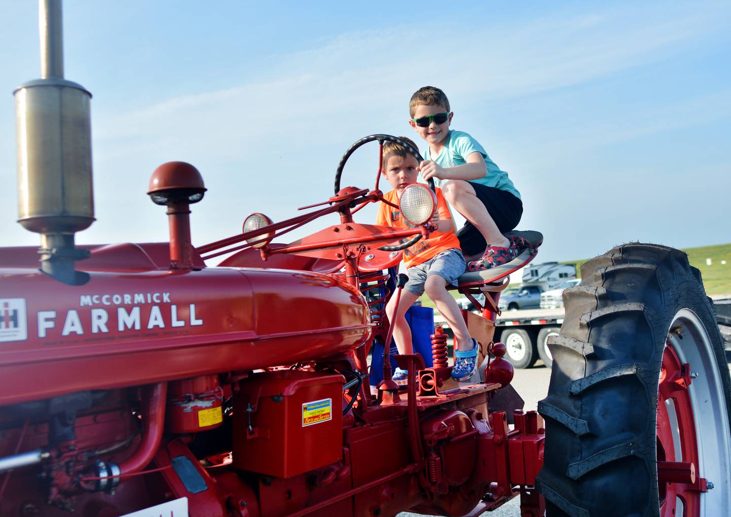 Wesley Herberg's great-grandsons – Lane Witte and Kyle Witte – horse around on the 1942 Farmall H tractor before the WHO Great Iowa Tractor Ride on June 16 at the Iowa Speedway in Newton.