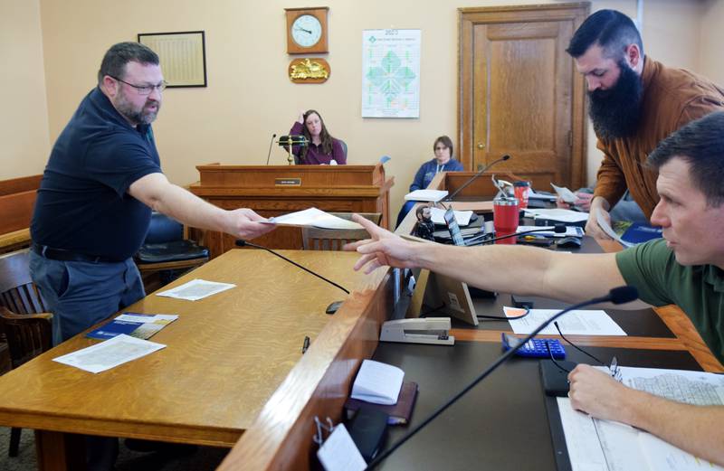 Matt McDonald, water quality initiative projects coordinator at IDALS, provides documents to the Jasper County Board of Supervisors on March 21. McDonald said the Iowa Department of Agriculture and Land Stewardship wants to work with the county to install saturated buffers and bioreactors near watersheds.