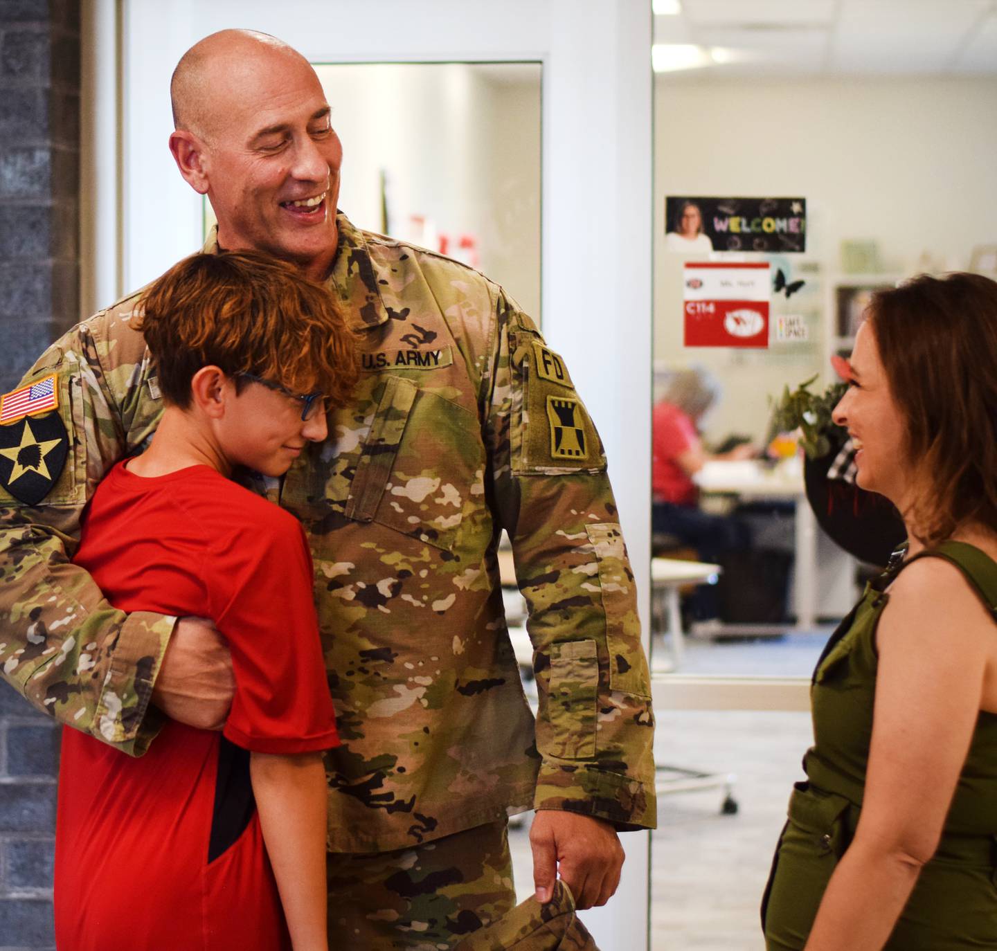 Cody Richards shares a laugh and gives a hug to son Jaiden Richards after surprising him of his return home from deployment oversears.