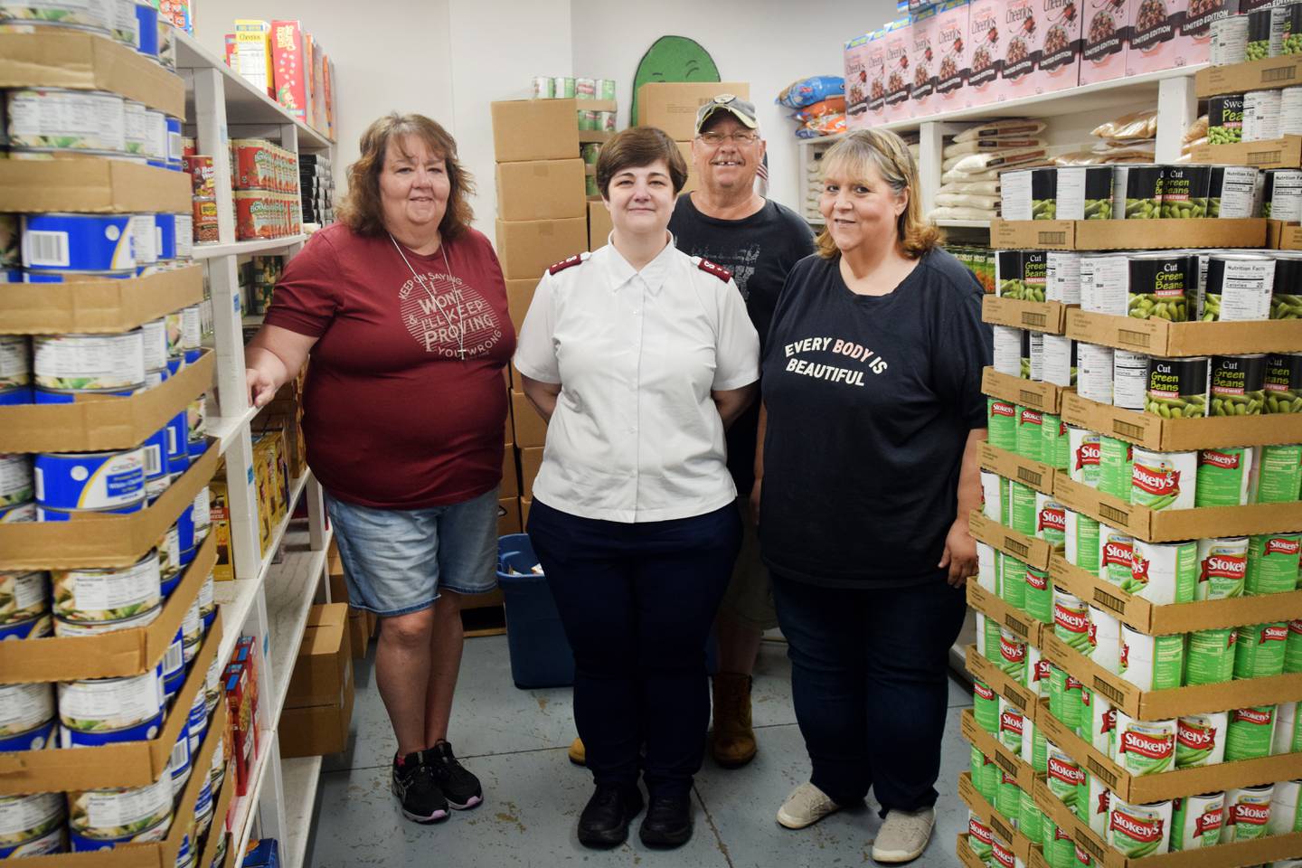 From left: Kayla Johnson, Captain Janelle Cleaveland, Ed Poe and Kelly Jo Zach pose for a photo inside the food pantry of the Newton Salvation Army. Cleaveland, who is leaving her post to lead a Salvation Army in Indiana, said she will miss her staff.