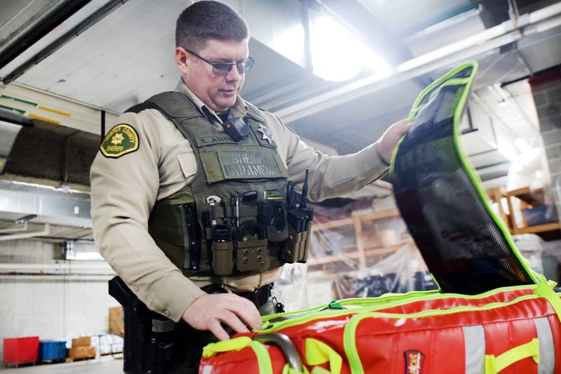 Steve Ashing, a reserve deputy paramedic for the Jasper County Sheriff's Office, opens a backpack full of medical supplies and equipment. Ashing is part of the advanced life support pilot program at the sheriff's office, which allows part-time reserve deputies with paramedic-level training to respond to emergency calls in rural areas and assist volunteer agencies.