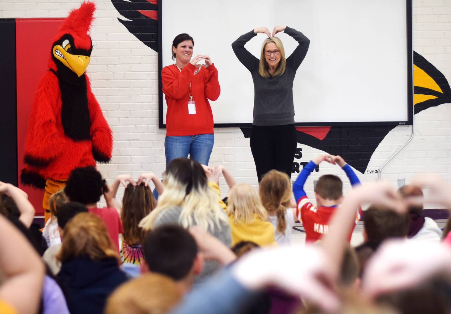 Tara Zehr, principal of Emerson Hough Elementary School, gets "big hearts" from her students after receiving the Above & Beyond Award from Newton Community Educational Foundation.