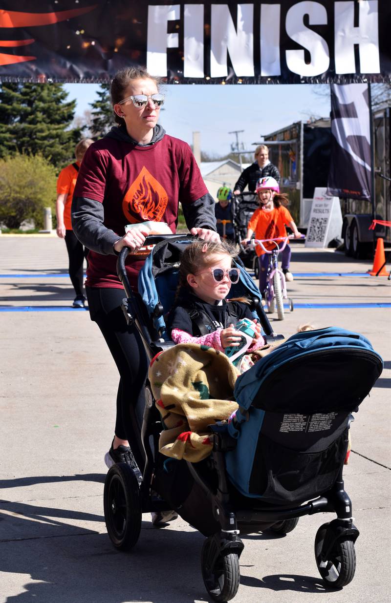 Runners, walkers and young bikers take off for the Run For Her Life 5K organized by nonprofit Phoenix Phase Initiative on April 29 at Legacy Plaza in Newton.