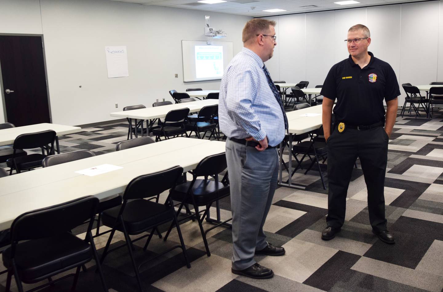 From left: Newton Superintendent Tom Messinger and Newton Police Chief Rob Burdess have a chat before guests arrive to the threat assessment training session June 9 at E.J.H. Beard Administration Center.