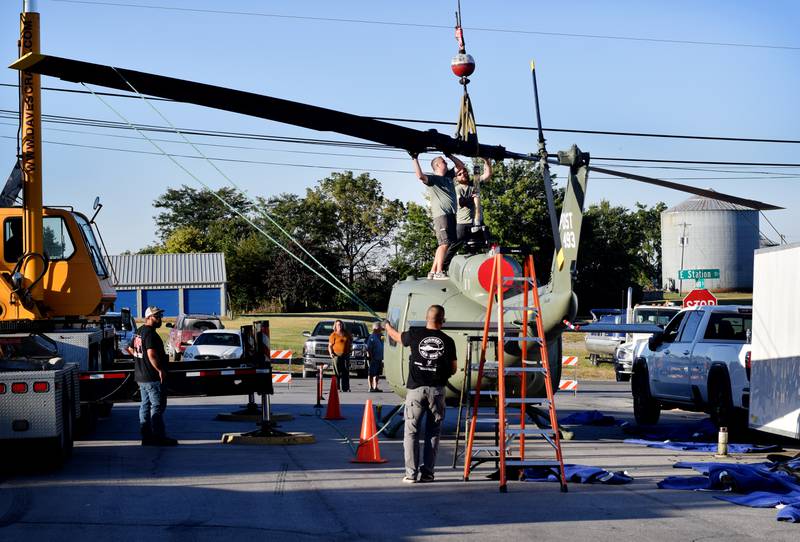 Crews from Midwest Aerospace and Dave's Crane & Wrecker Service help lift the main rotor blade to a Huey helicopter on Sept. 30 in Baxter.