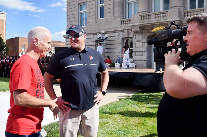 Keith Murphy of WHO 13 on Sept. 4 speaks with Newton Head Football Coach Andy Swedenhjelm before his live broadcast on the lawn of the Jasper County Courthouse in downtown Newton. Residents gathered for a Newton pep rally and RVTV festivities.