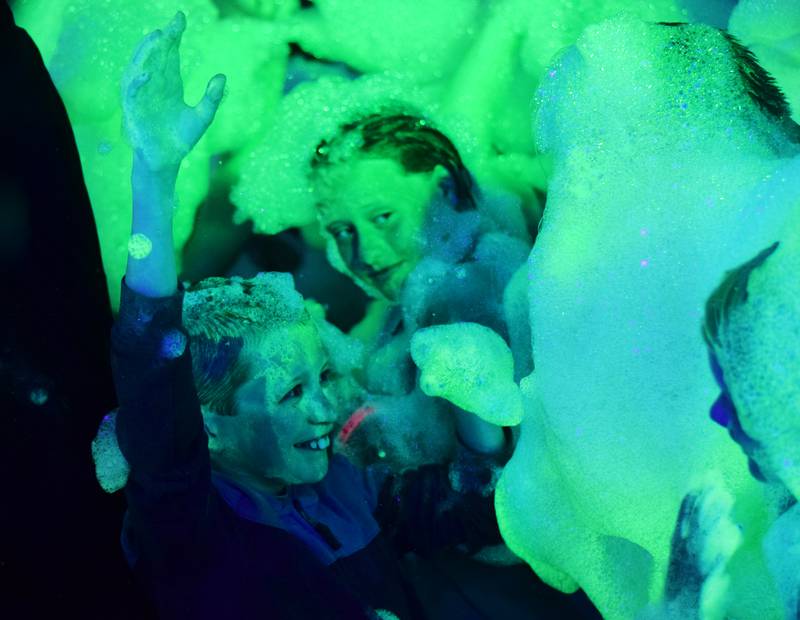 Kids participate in Driving Cap Entertainment's UV Glow Foam Party during Newton Fest on June 9 in Maytag Park in Newton.