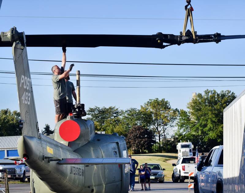 Crews from Midwest Aerospace and Dave's Crane & Wrecker Service help lift the main rotor blade to a Huey helicopter on Sept. 30 in Baxter.