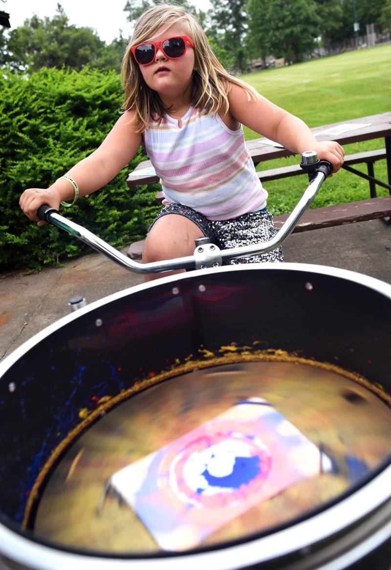 Iowa State University Extension and Outreach hold a spin art bike activity during Newton Fest on Saturday, June 10 at Maytag Park.