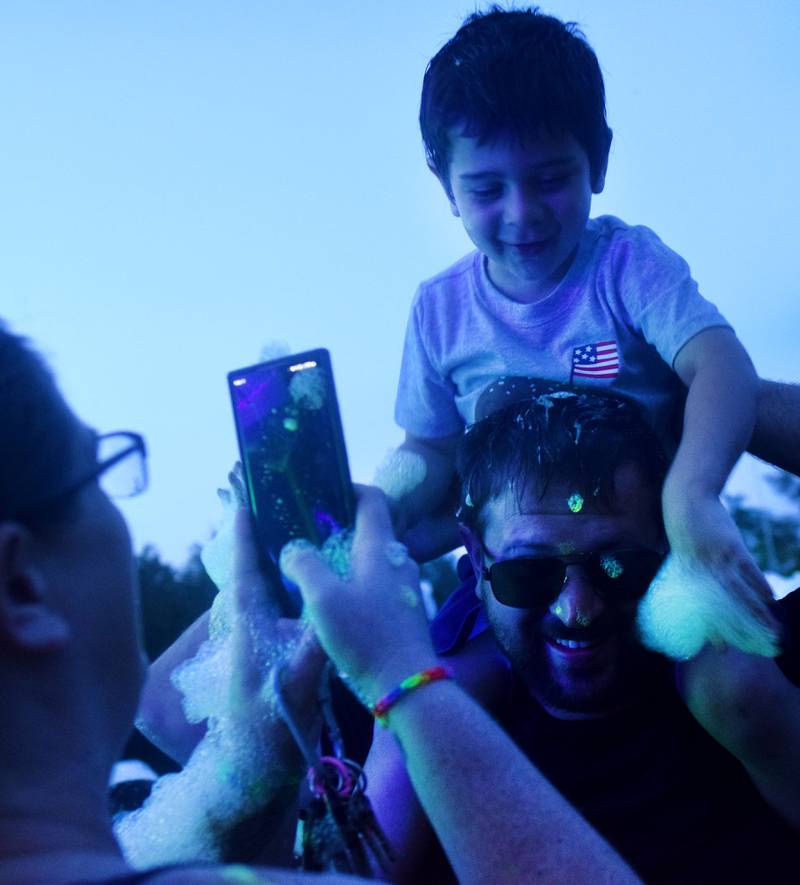 Kids participate in Driving Cap Entertainment's UV Glow Foam Party during Newton Fest on June 9 in Maytag Park in Newton.
