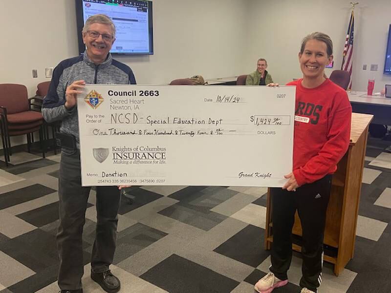Bruce Corlew, treasurer and program director of the Knights of Columbus presents Robyn Friedman, Newton Community Schools Board President with a $1,424 check.