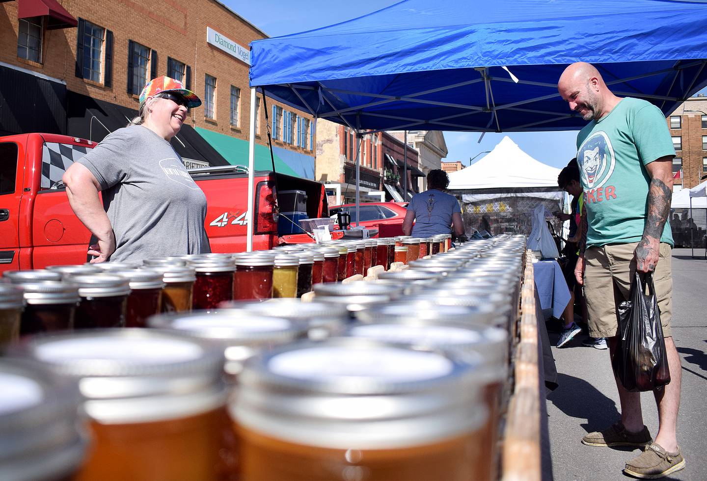 Nancy Woody of Nancy's Canned Creations sells a jar of her homemade jam to a customer June 1, 2021, at the Newton Farmers Market.