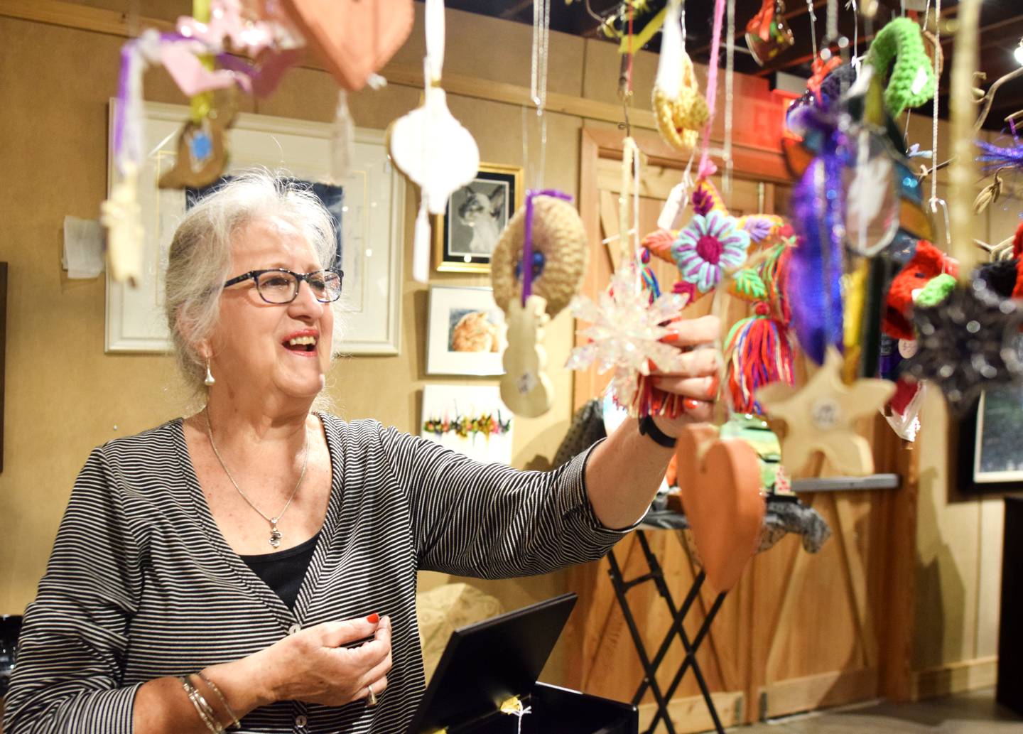 Terri Ayres, volunteer manager of the Geisler-Penquite Gift Shop at the Center for Arts & Artists, showcases the many handmade and donated items for sale at the store, the proceeds of which benefit creative-based programming and projects for youth.