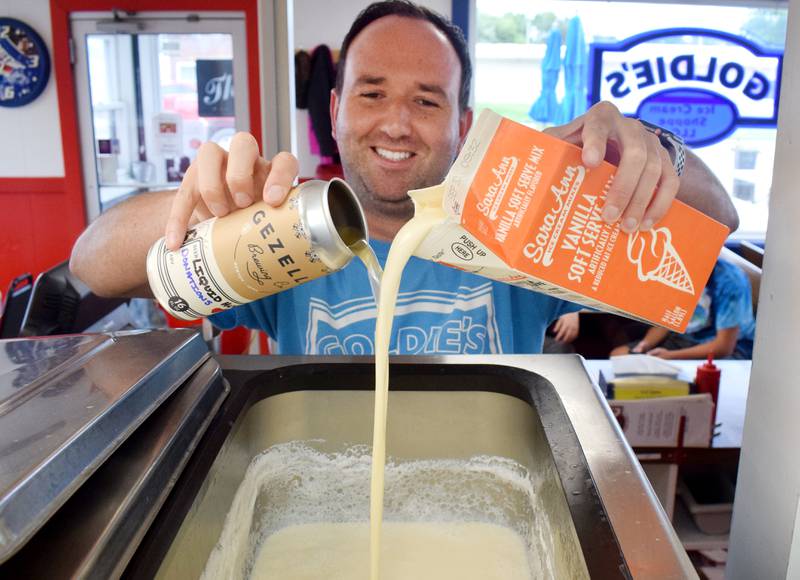 Brad Magg, owner of Goldie's Ice Cream Shoppe, serves a cone of beer-flavored ice cream infused by the Liquid Hug lager from the Newton-based taproom Gezellig Brewing Company in 2019. Goldie's has partnered with Gezellig again to bring back beer ice cream during Cy-Hawk week, the proceeds of which will go towards the Carson King Foundation.