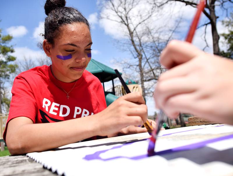 Newton students on May 4 painted Christmas light displays for the city's Maytag Park Holiday Lights during Red Pride Service Day.