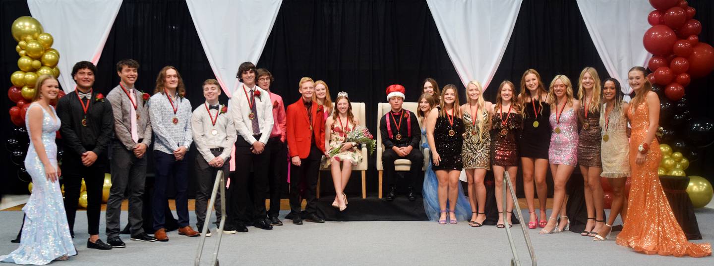 The 2022 Newton Homecoming queen and king, Kaitlyn Bloom and Brody Bauer, pose for pictures with other homecoming court candidates on Sept. 15 during a coronation ceremony at Newton High School.