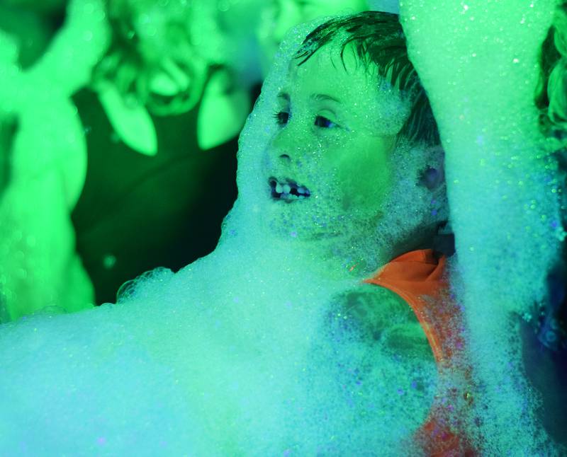 Kids participate in Driving Cap Entertainment's UV Glow Foam Party during Newton Fest on June 9 in Maytag Park in Newton.