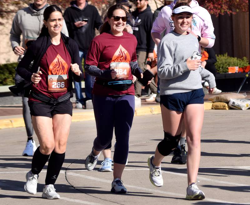 Runners, walkers and young bikers take off for the Run For Her Life 5K organized by nonprofit Phoenix Phase Initiative on April 29 at Legacy Plaza in Newton.