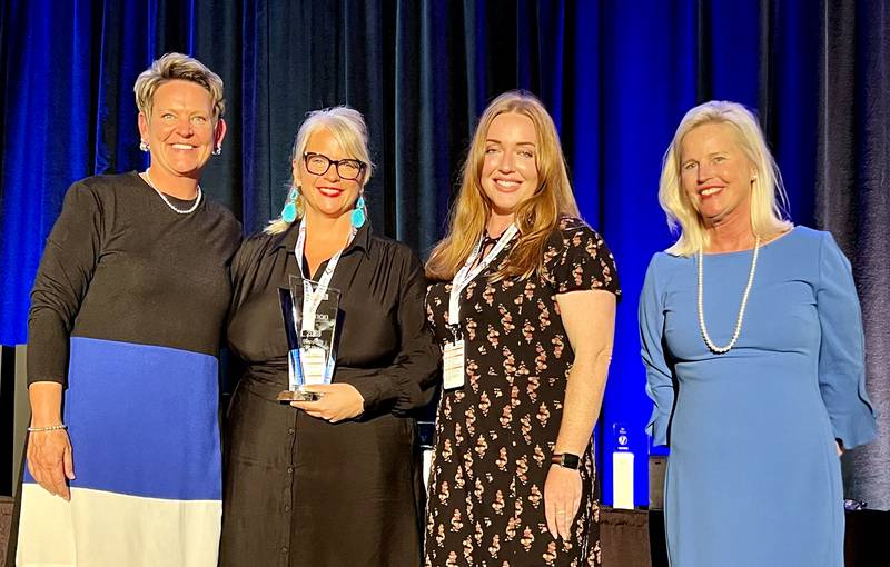 SanMar was named Supplier of the Year for the 2023 sales year. The award was presented during the Vernon National Sales Meeting at the Hilton Hotel & Suites in Indianapolis, Ind. Presenting the Awards was Vernon’s Vice President of Sales and Marketing Lisa Hubbard, left, and National Sales Manager Stephanie Critchfield, right. Accepting the award for SanMar was Account Executive Marissa Holman, center left, and Strategic Account Manager Anna Tucker, center right.