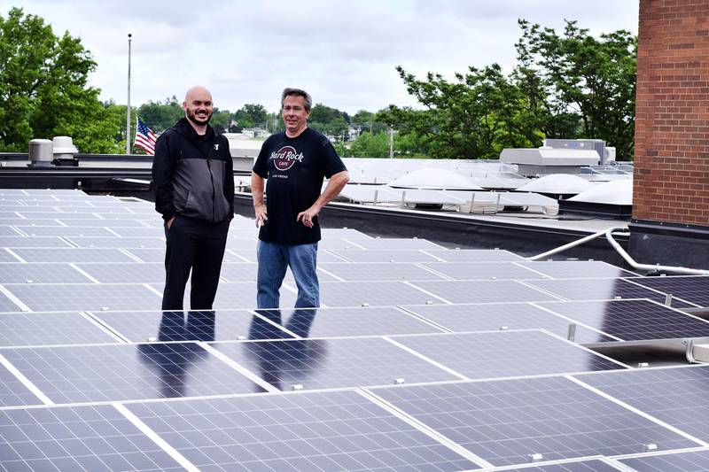 From left: Newton YMCA CEO Lucas Hughes and property manager Kevin Clark stand on the roof the facility on May 31 to showcase the more than 500 solar panels installed.