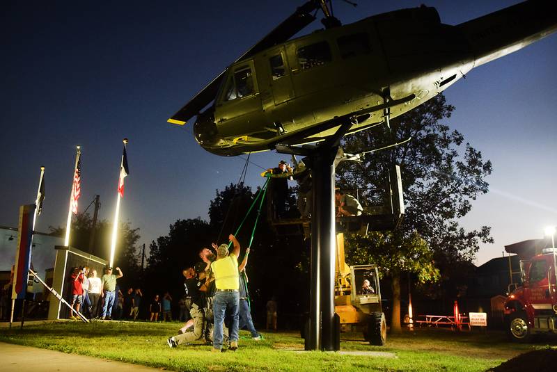 Crews pull on the Huey helicopter to get it into position on its raised platform on Sept. 30 in Baxter.