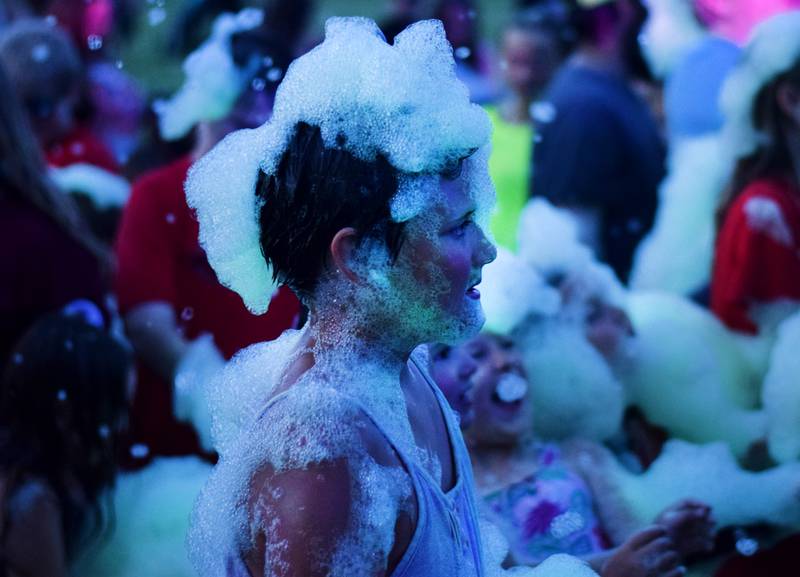 Kids participate in Driving Cap Entertainment's UV Glow Foam Party during Newton Fest on June 9 in Maytag Park in Newton.