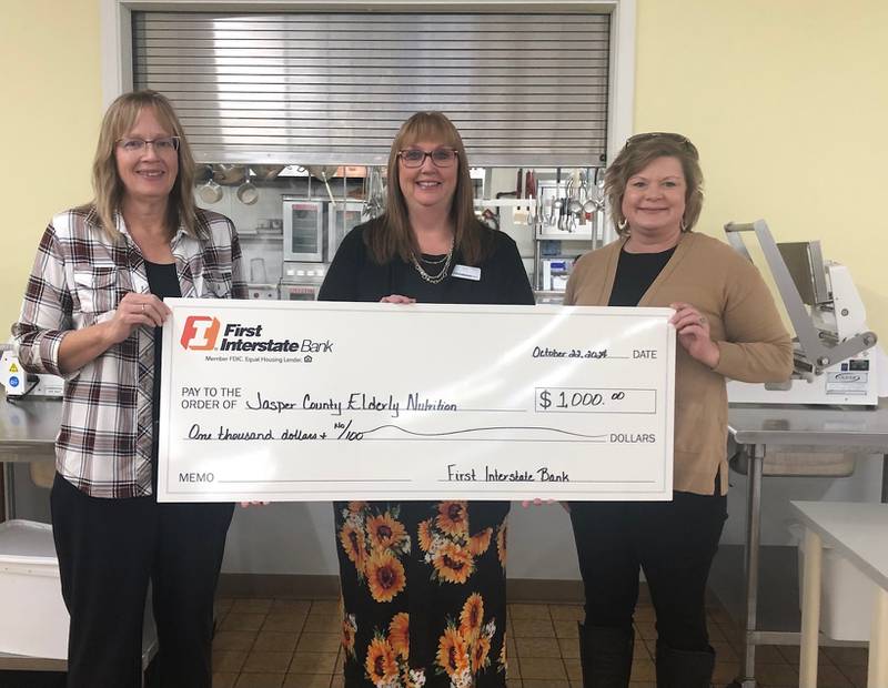 Left, Kelli Van Manen, Jasper County Elderly Nutrition Program Director, accepts a check from First Interstate Bank representatives Sue Nolin and Jamie Bennett.