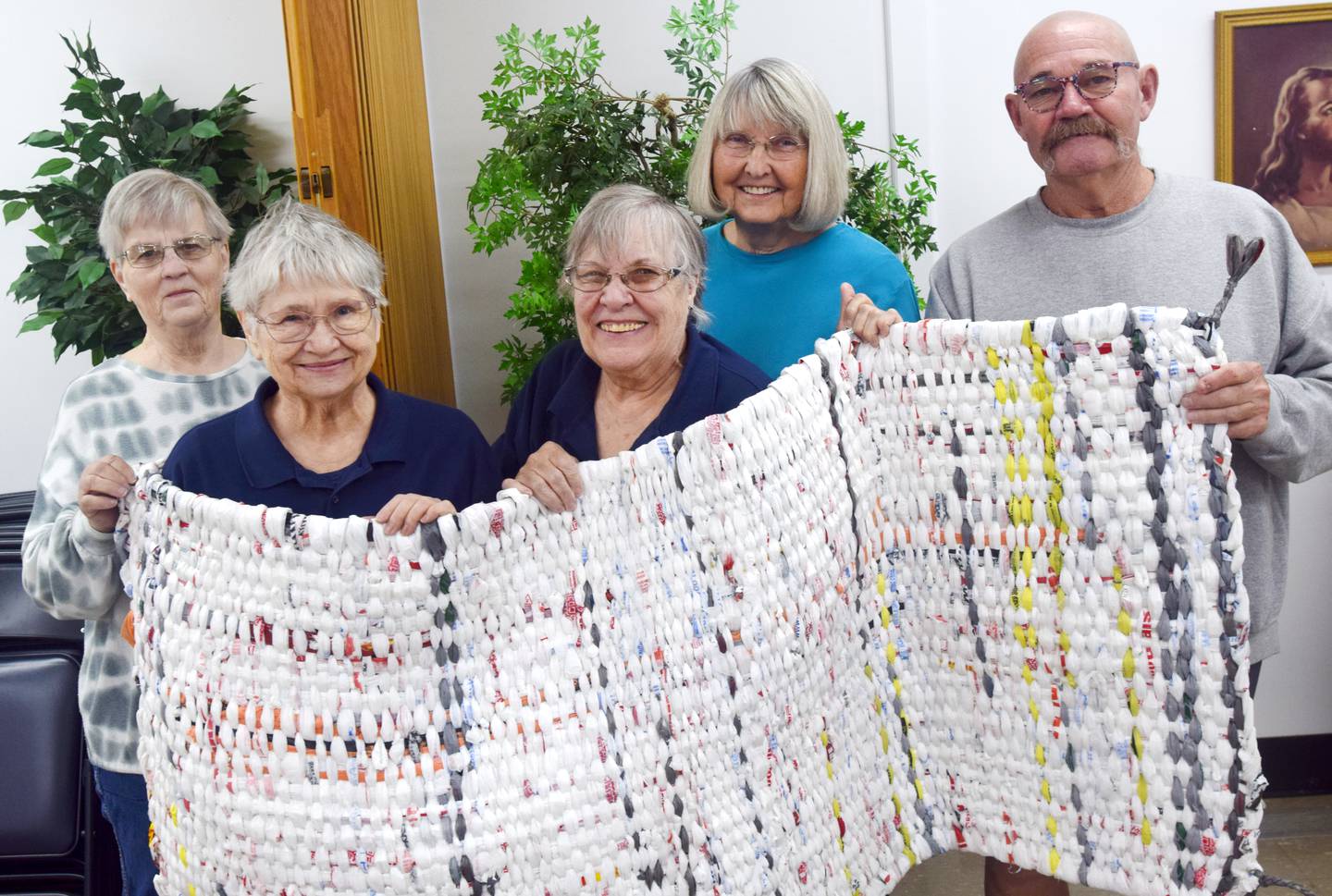 From left: Deb Van Brogen, Jan Lewis, Joyce Stonehocker, Ina Heidemann and Kyle Abel show off a completed sleeping mat made out of plastic grocery bags.